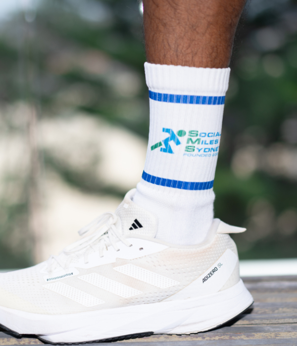 White Social Miles Sydney logo grip socks worn with running shoes.