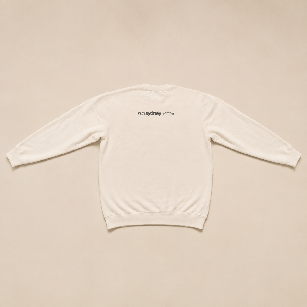 Back view of the warm white Social Miles Sydney crest runSydney crewneck pullover with the runSydney bridge mark across the upper back.