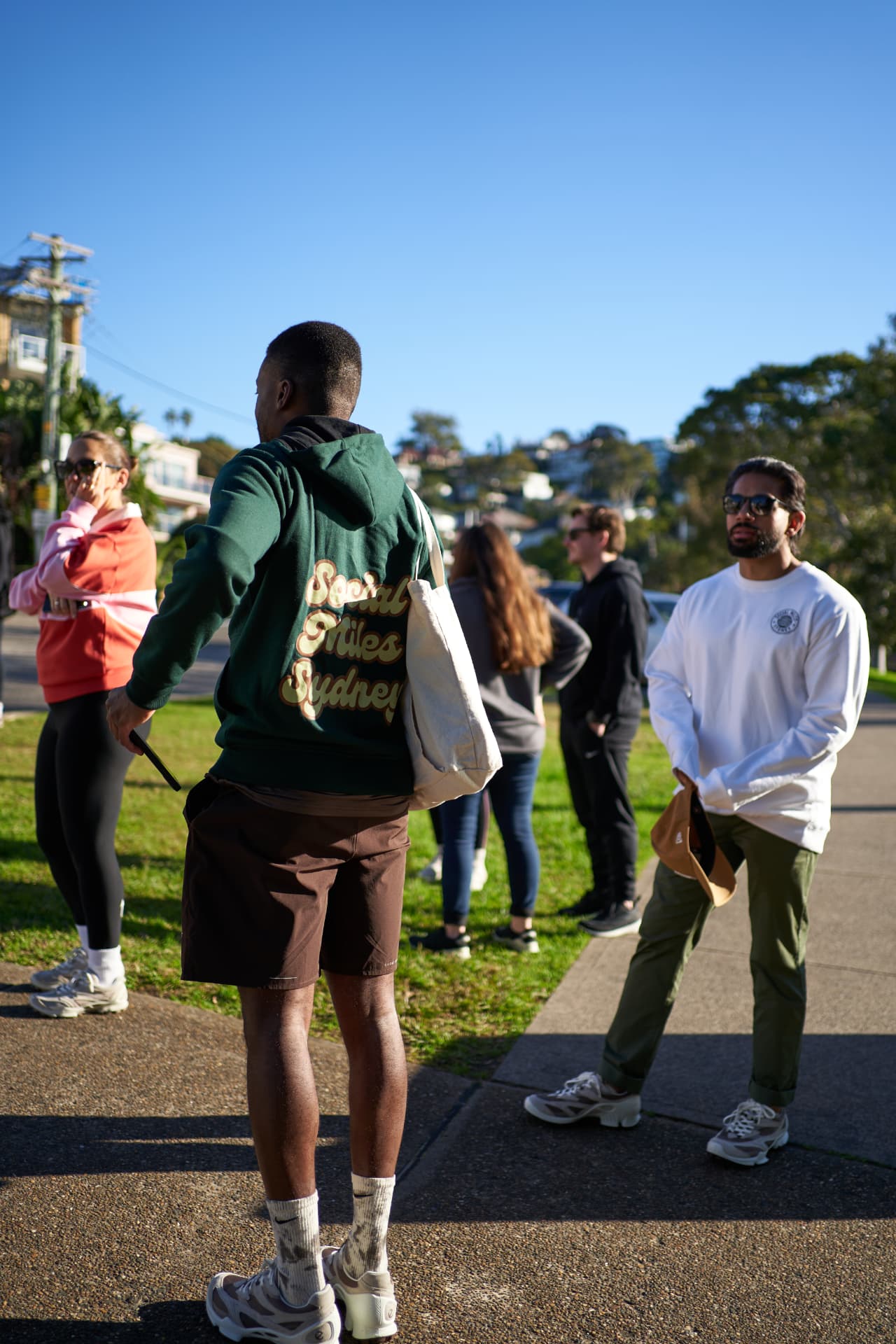 Social Miles Sydney members in club clothing gathering on the grass before a community event.