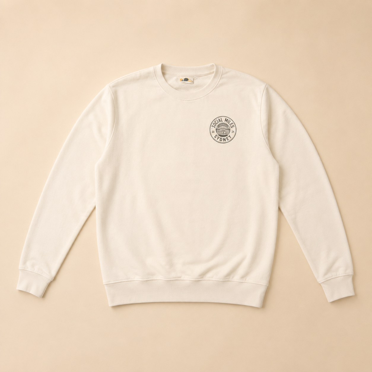 Front view of the warm white Social Miles Sydney crest runSydney crewneck pullover with the circular club crest on the chest.