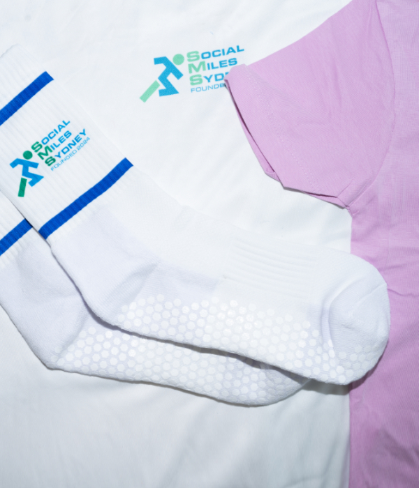 White Social Miles Sydney logo grip socks folded beside a pink club tee.