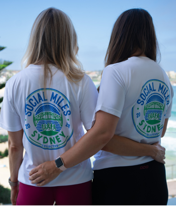 Member wearing the white Social Miles Sydney performance tee, back view with the circular Sydney crest.