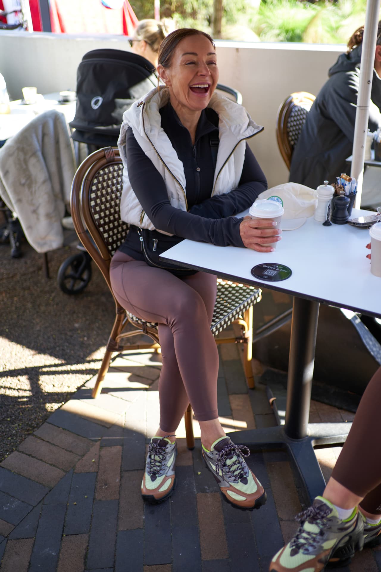 A Social Miles Sydney member laughing over coffee after a Sunday run and walk.