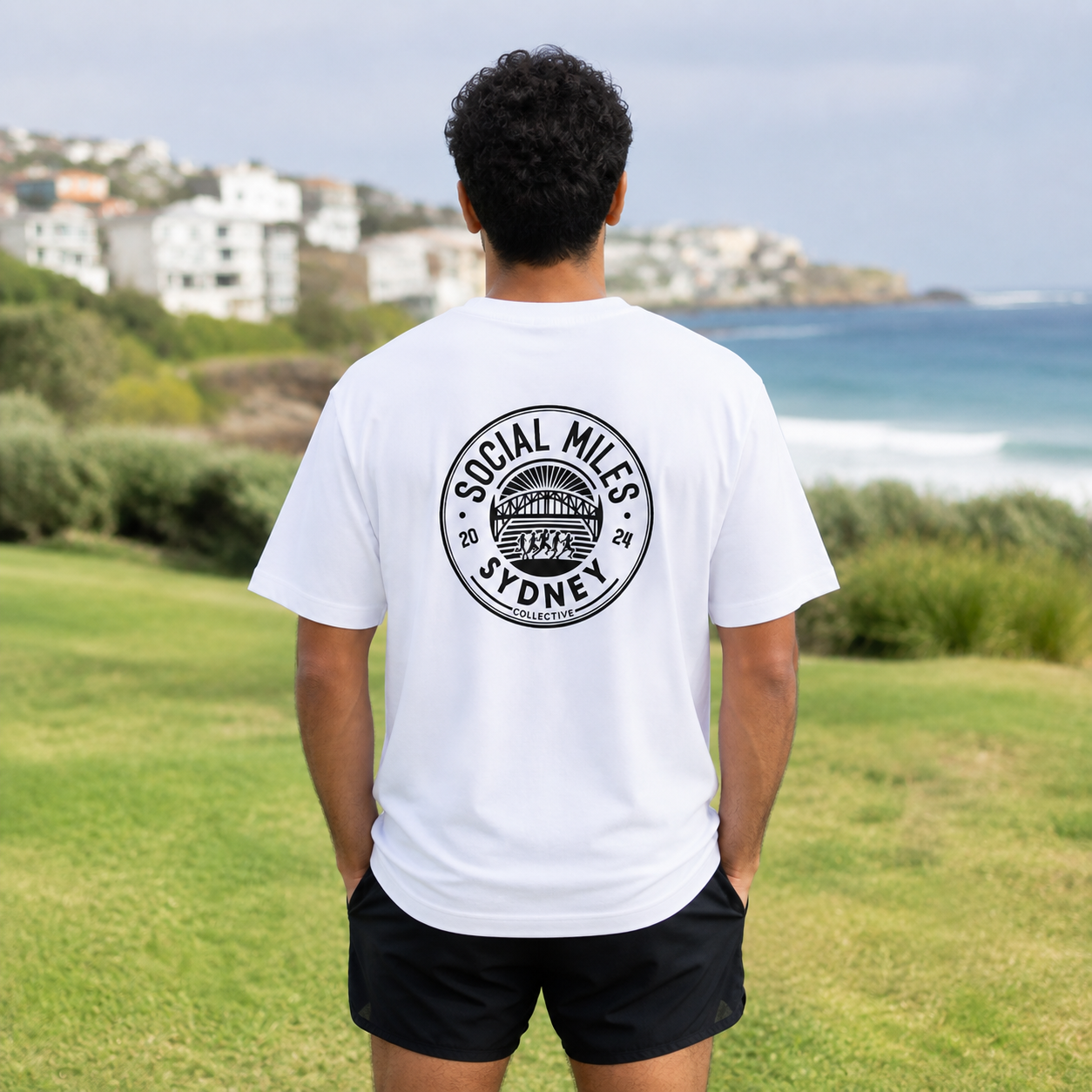 Member wearing the white runSydney oversized Social Miles Sydney tee, back view with the circular Social Miles crest.