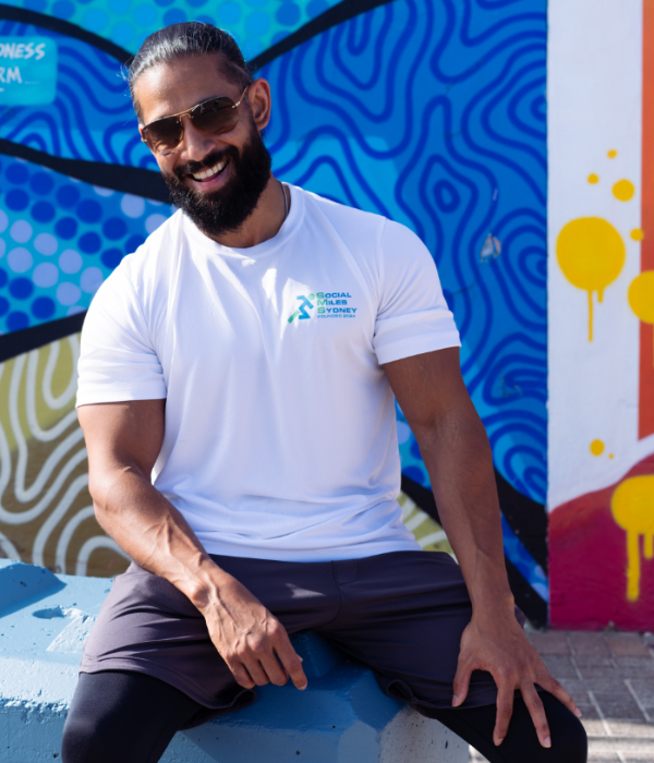 Member wearing the white Social Miles Sydney performance tee, front view with the small chest club mark.