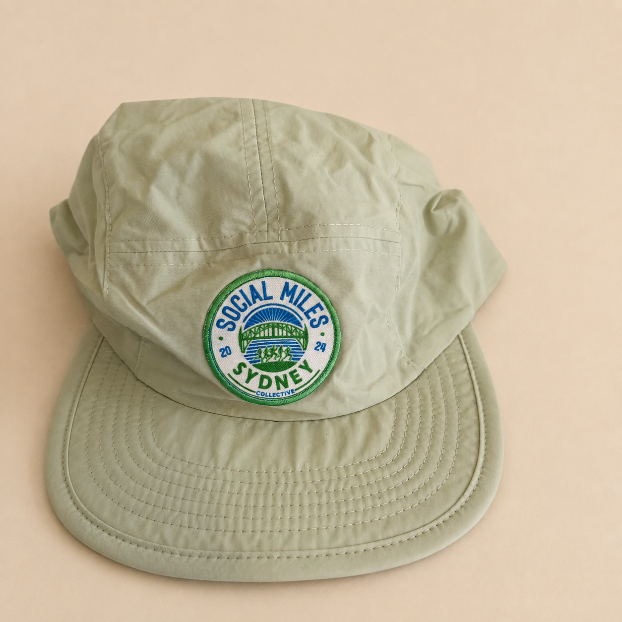 Pale mint Social Miles Sydney running cap with the embroidered circular club crest.