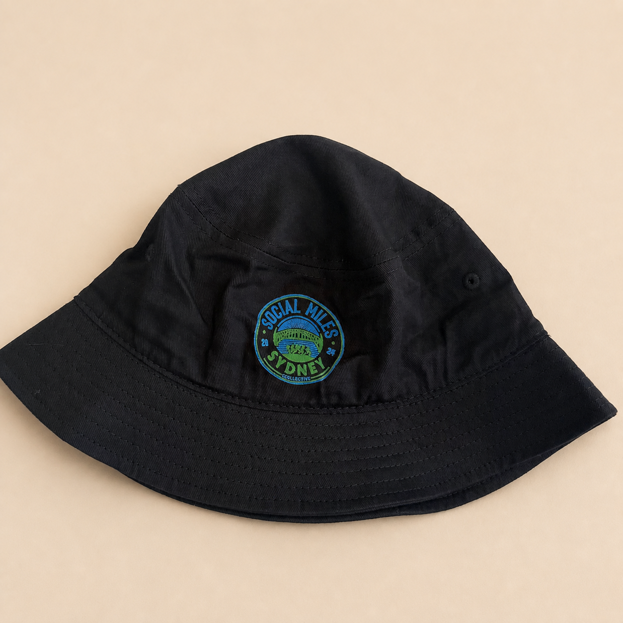 Navy Social Miles Sydney bucket hat with the embroidered blue and green circular club crest.