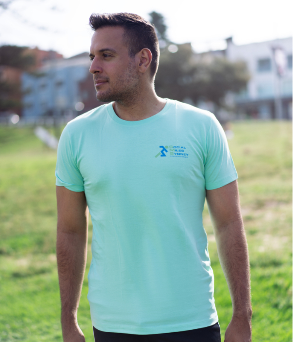 Member wearing the mint Social Miles Sydney club tee, front view with a small chest logo.
