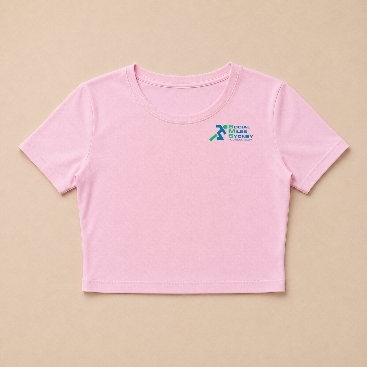Front view of the pink cropped Social Miles Sydney tee with the original blue and green club mark at the chest.